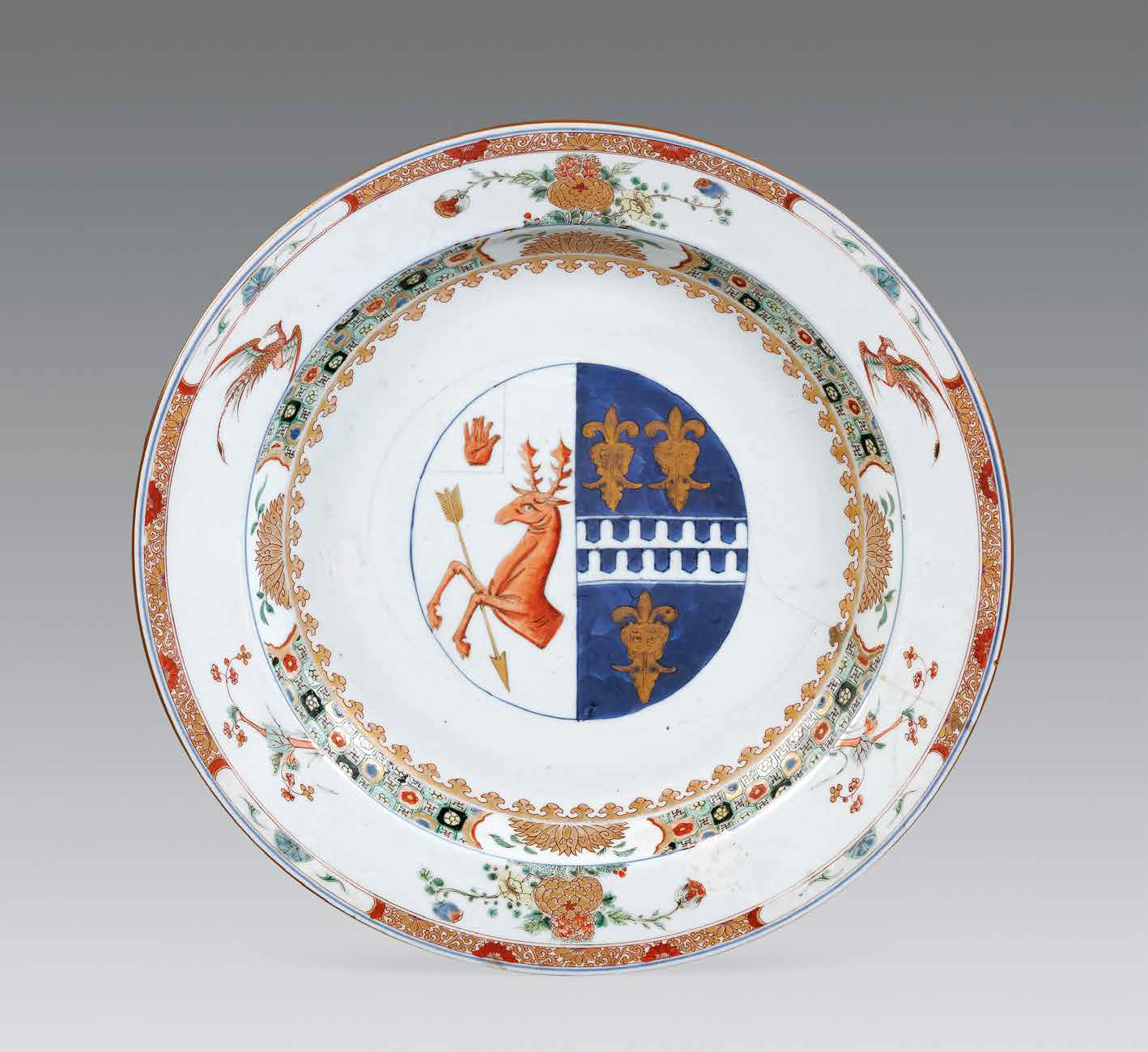 “外銷瓷”是指我國生產(chǎn)的，專門銷往國外的瓷器，清代“一口通商”時期，中國瓷器遠銷歐美，對歐美人民生活影響深遠。這一時期輸出的瓷器種類眾多，有粉彩、廣彩、青花、五彩等，器物造型及紋飾圖案既保留了中國制瓷藝術(shù)的傳統(tǒng)特征，又汲取了歐美的藝術(shù)精華，從而燒制出了大量精美的瓷器。圖為清康熙Decker家族和Watkins家族聯(lián)姻紋章大盤。外銷瓷中常見兩個家族組合紋章的紋章瓷，這樣的瓷器通常是為家族成員聯(lián)姻而定